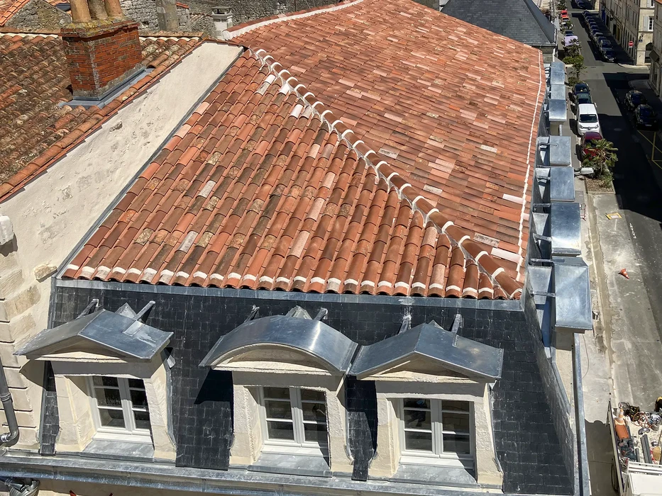 Toiture en cours de rénovation vue de l'extérieur, avec travaux de couverture métallique