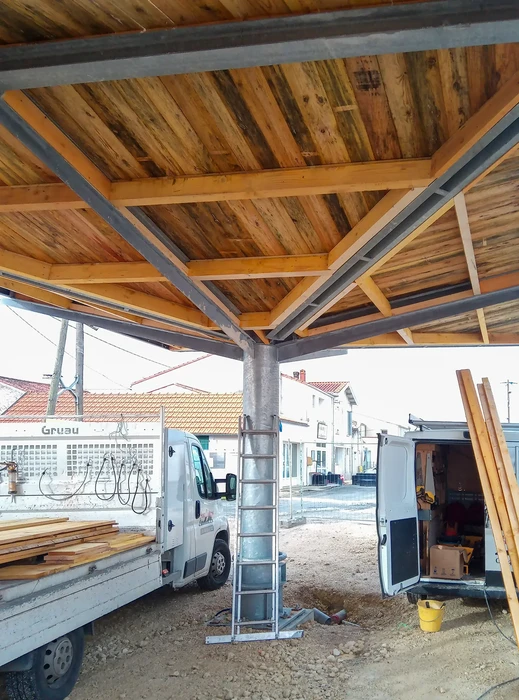 Chantier de construction extérieur avec structure métallique et charpente bois