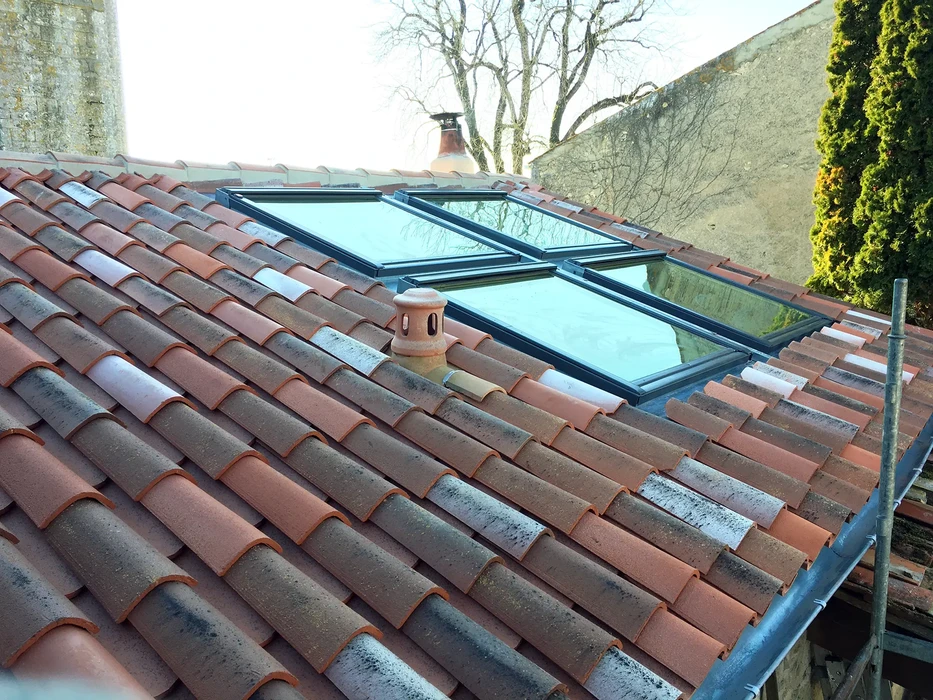 Chantier de construction extérieur avec ouvrier sur nacelle élévatrice jaune installant une structure de toiture