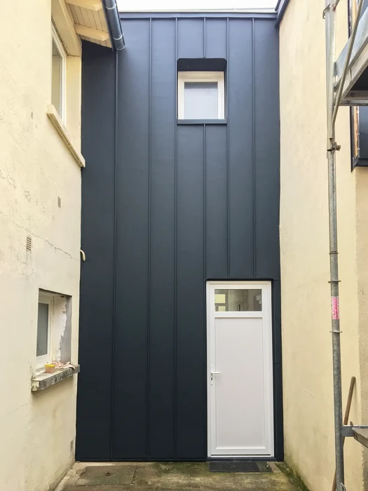 Vue extérieure sur toiture urbaine avec couverture métallique zinc ou plomb, solins et faîtages apparents