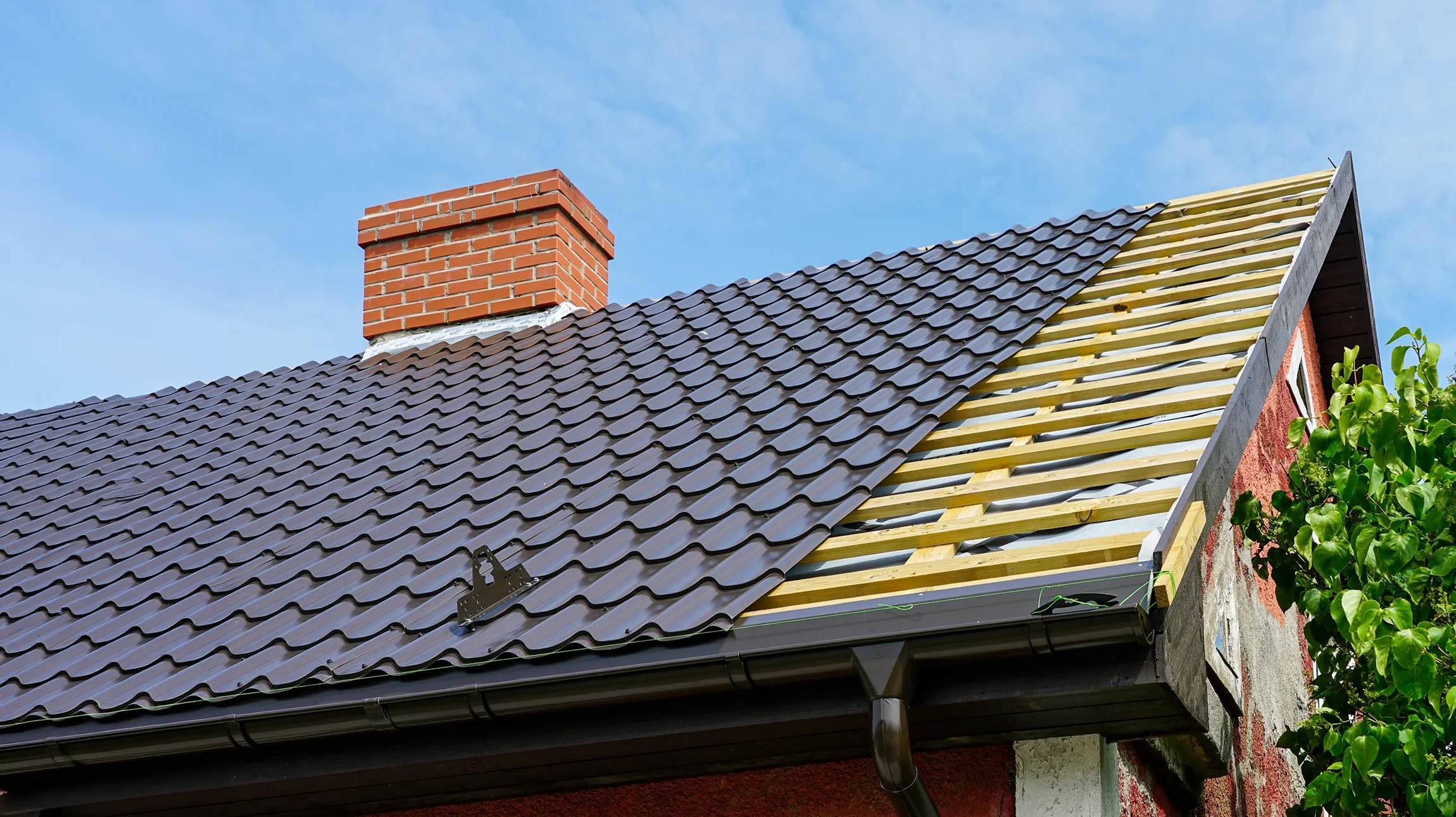 Vue aérienne de toitures urbaines avec tuiles en terre cuite rouge et couvertures métalliques ondulées