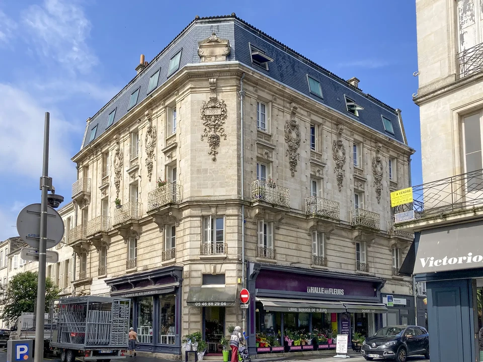 Chantier de construction ext&eacute;rieur montrant une toiture en cours de r&eacute;alisation sur maison en parpaings gris